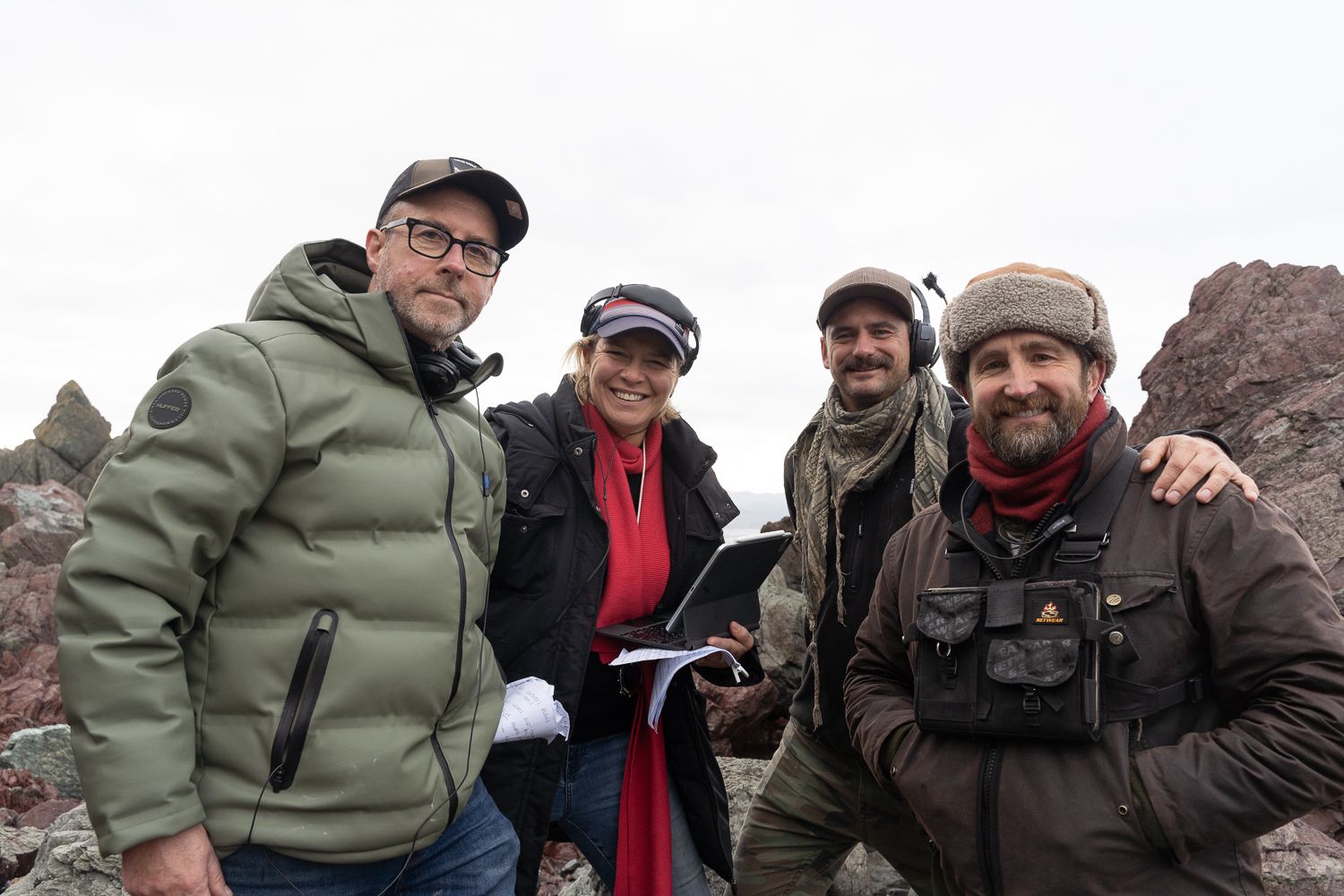 A group photo of crew on the set of Secrets at Red Rocks. Four people smile at the camera in a behind-the-scenes image.