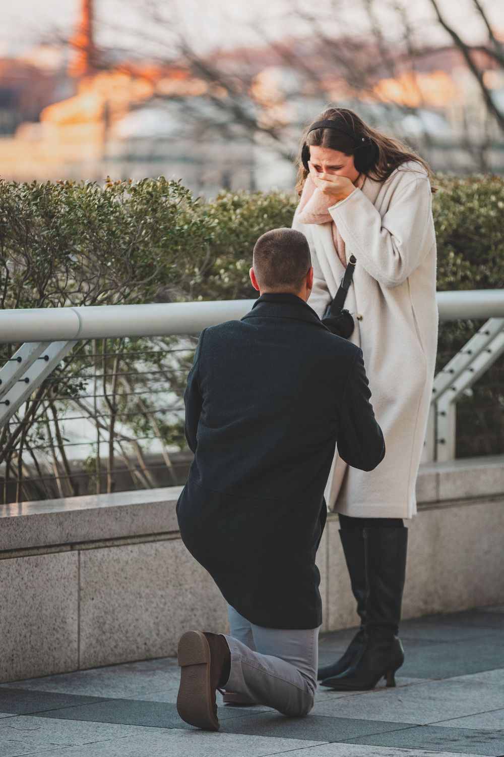A proposal sequence showing someone kneeling  on a city terrace during sunset at the Kennedy center, a great Dc winter proposal location
