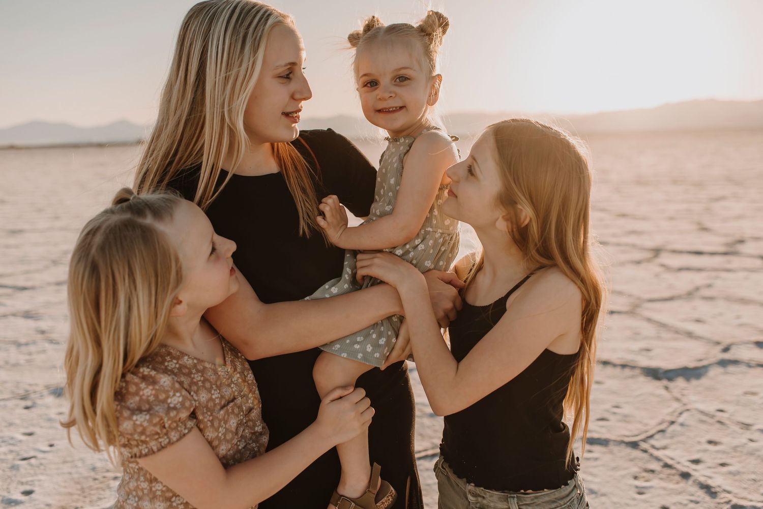 Family embracing together on the white salt flats during a sunset photoshoot.