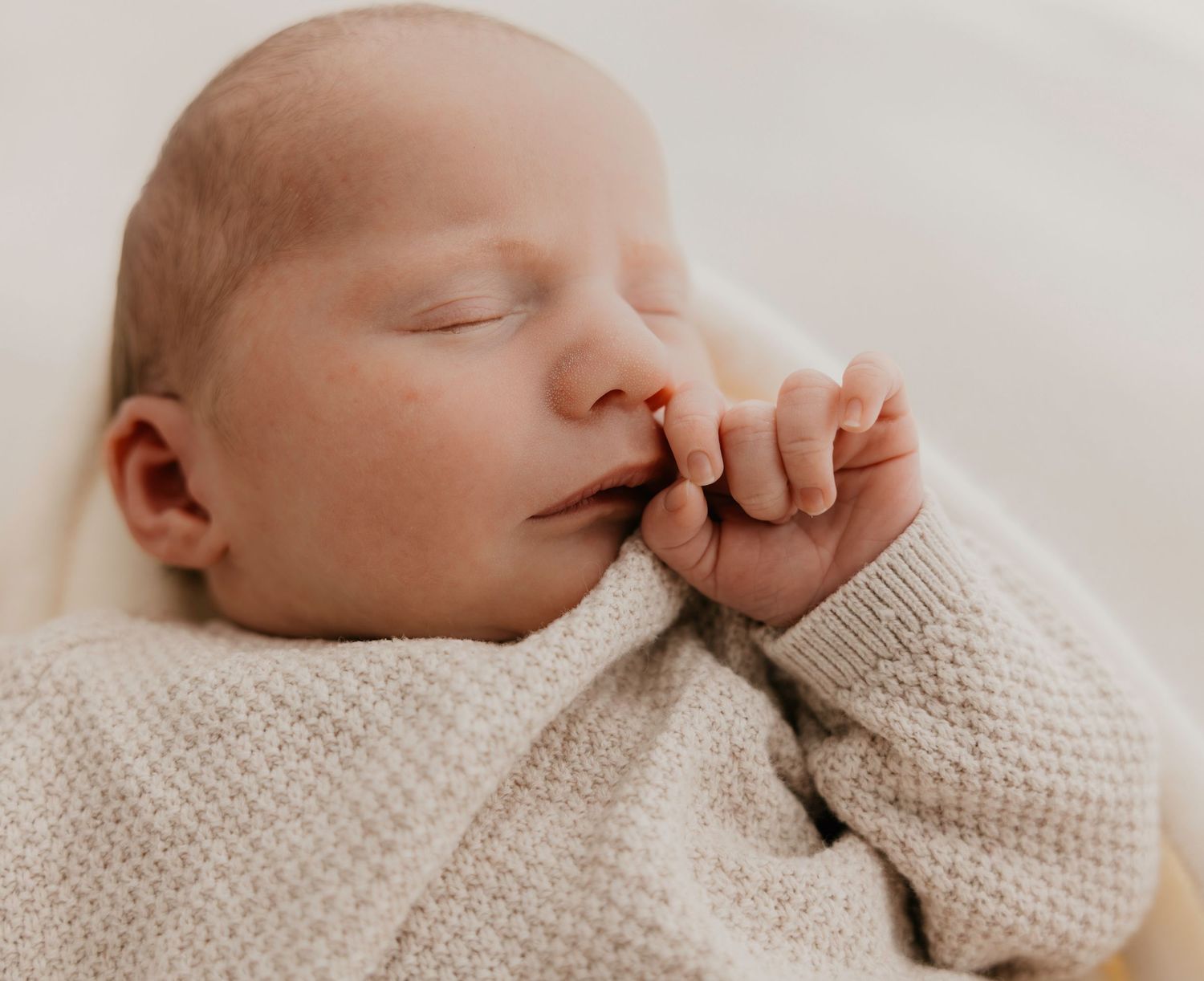 Slapend newborn baby’tje op zachte deken in warme studio in Hulste