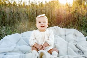 White blanket spread out on grass in a sunlit meadow during golden hour.
