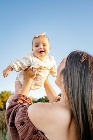 Joyful moment captured against blue sky during golden hour outdoor photoshoot.