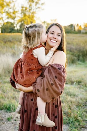 Tender embrace shared in a sun-drenched field with autumn wildflowers.
