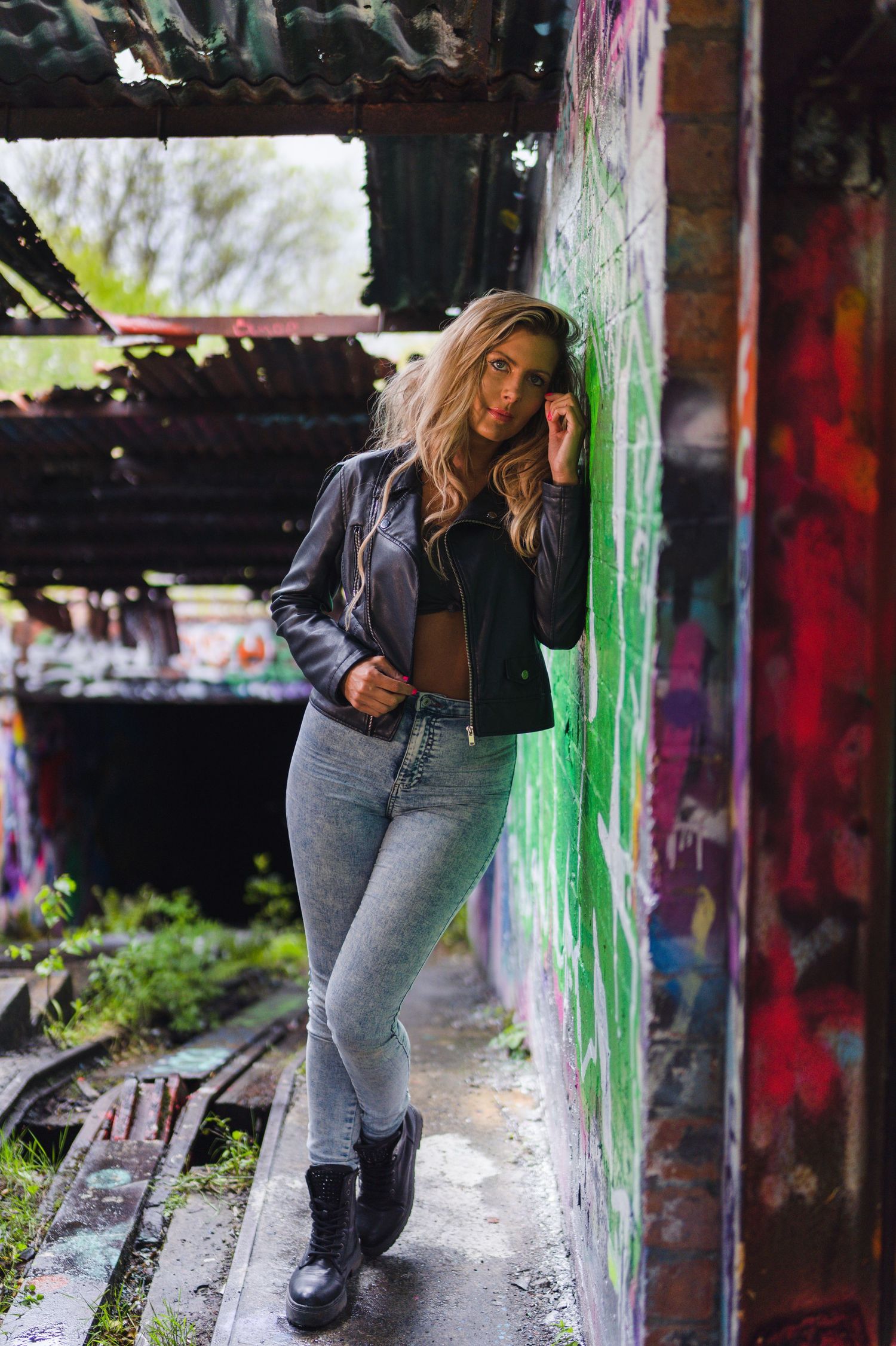 Urban portrait session in graffiti-covered location with casual street style.
