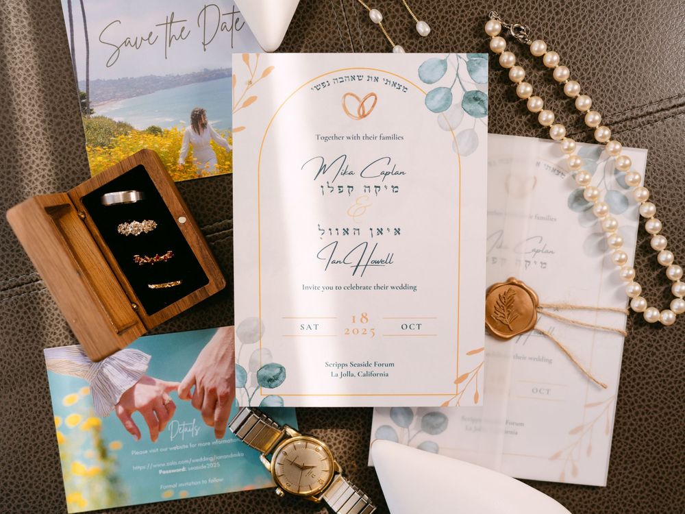 A collection of wedding invitations and stationery with elegant calligraphy and romantic designs displayed on a dark surface.