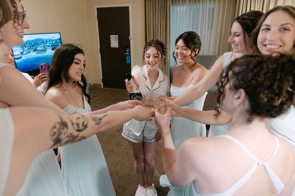 A group of dancers in white outfits practice choreography together in a dance studio.