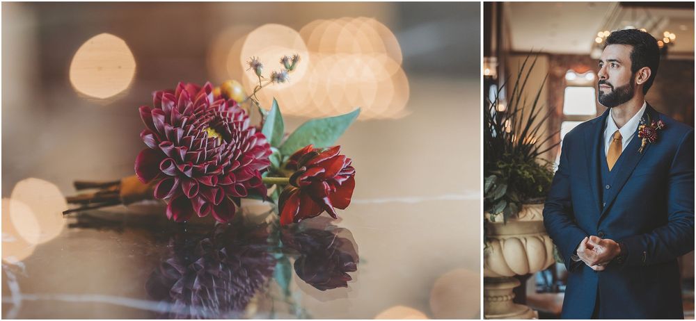 Pink and red floral arrangement on reflective surface with bokeh lights and groom in navy suit with boutonniere.