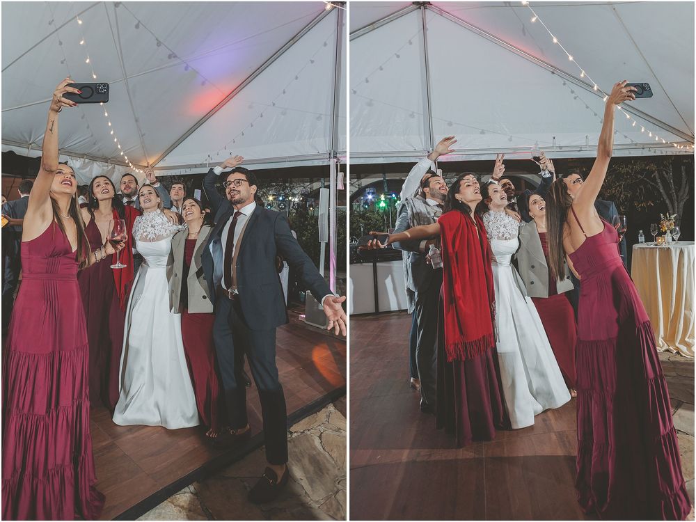 Wedding party dancing and celebrating on the dance floor during a reception under a white tent.