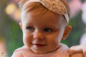 A series of close-up photos showing a baby wearing a lace headband and pink outfit.