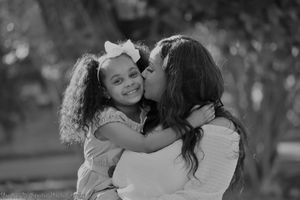 A series of black and white photographs showing intimate family moments of hugging and embracing in outdoor settings.