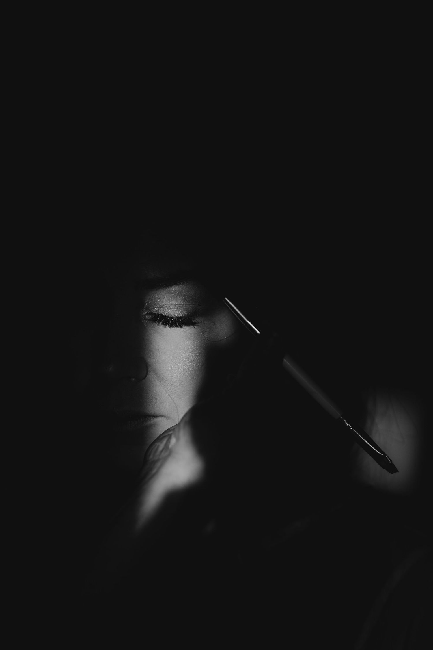 A series of dark abstract black and white images showing faint streaks of light against a shadowy background.