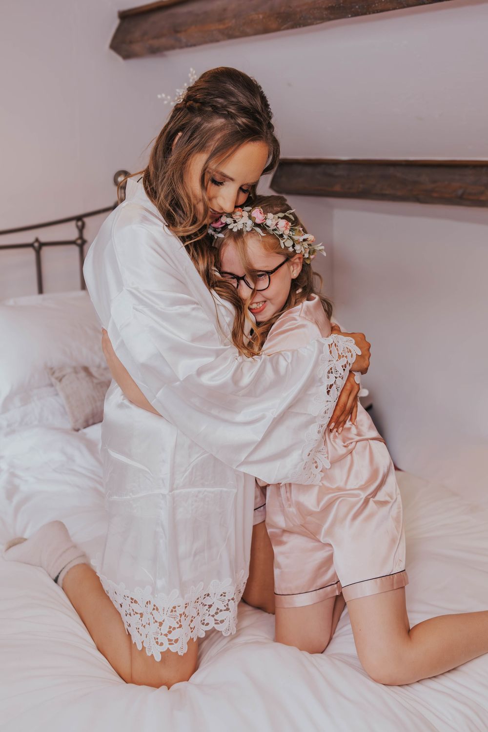 Romantic boudoir photography series featuring soft white lace and delicate poses on light bedding in muted tones.