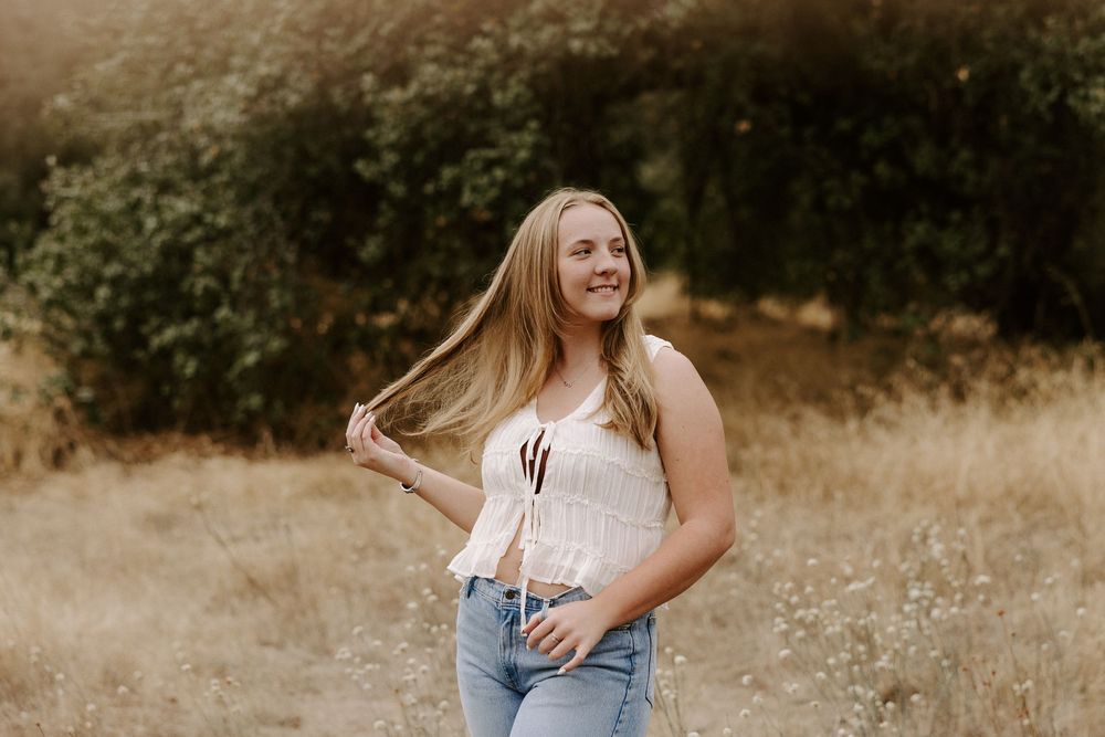 Candid lifestyle photography in a sun-drenched meadow with warm autumn tones.