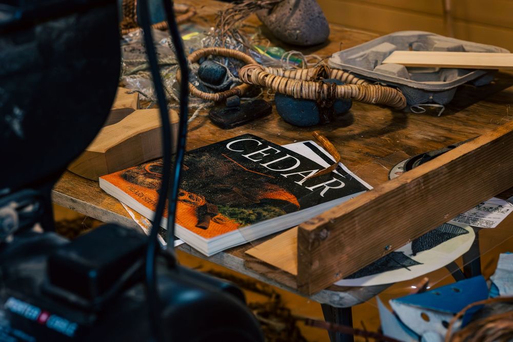 Various shoemaking tools and equipment arranged on a wooden workbench in a cobbler's workshop.