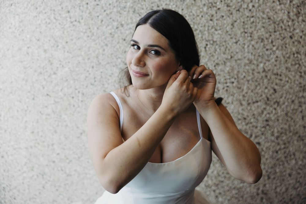 Elegant bridal portrait showcasing a white wedding dress against a neutral background.