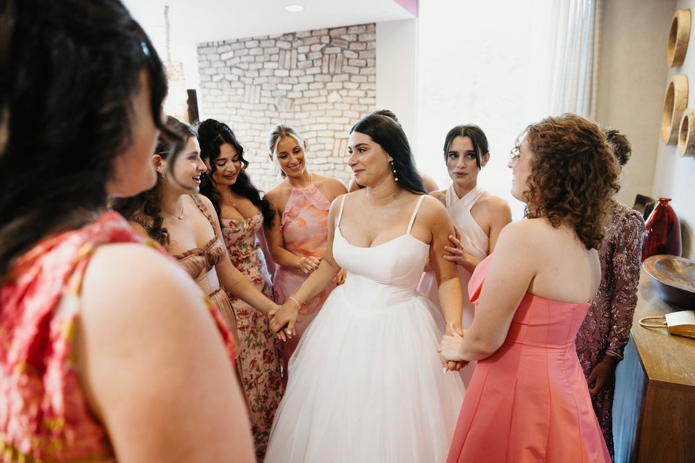 Wedding celebration with bridesmaids in pink and floral dresses.
