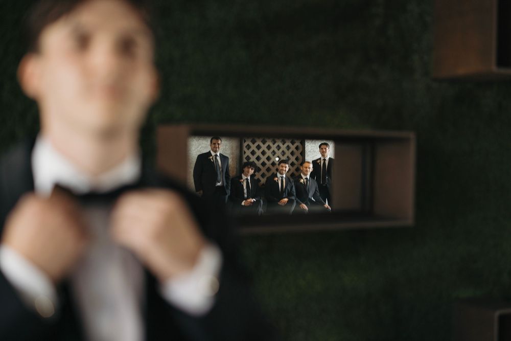 Creative mirror reflection shot of formal attire through decorative wall opening.