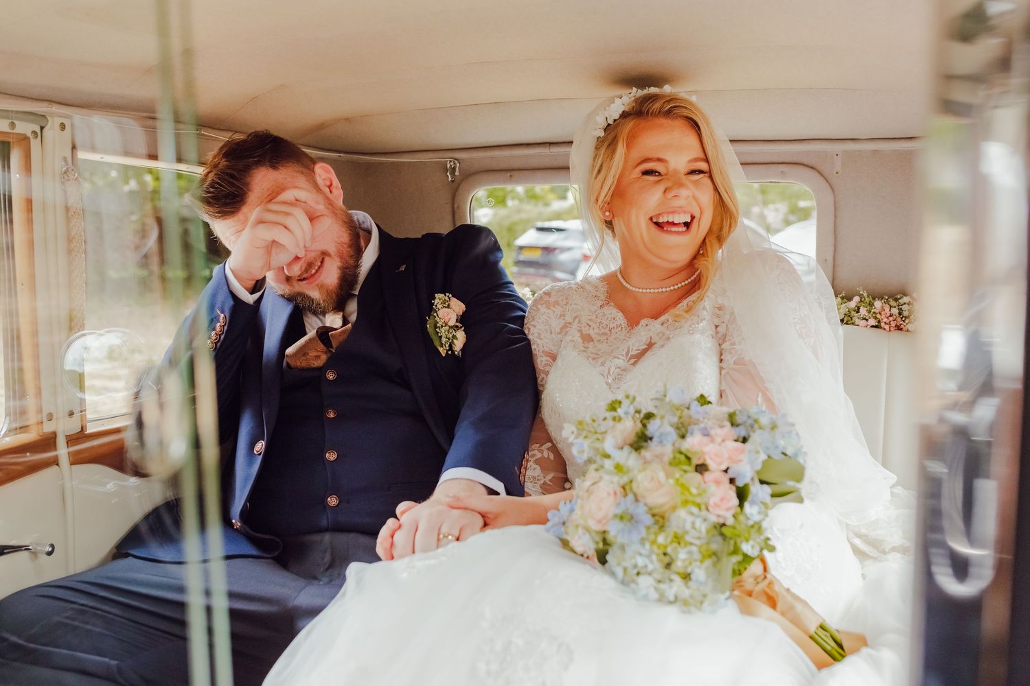 Just a married couple laughing in their wedding car, relaxed and joyful wedding photography