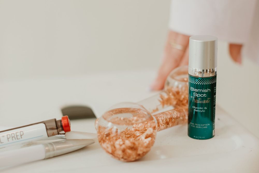 Beauty products including skincare serum and cosmetic bottles on a light surface.