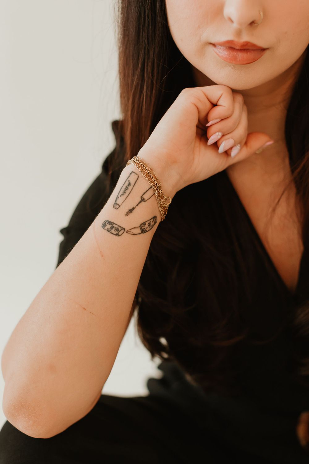 Close-up of a chain tattoo design on wrist with black sleeve.