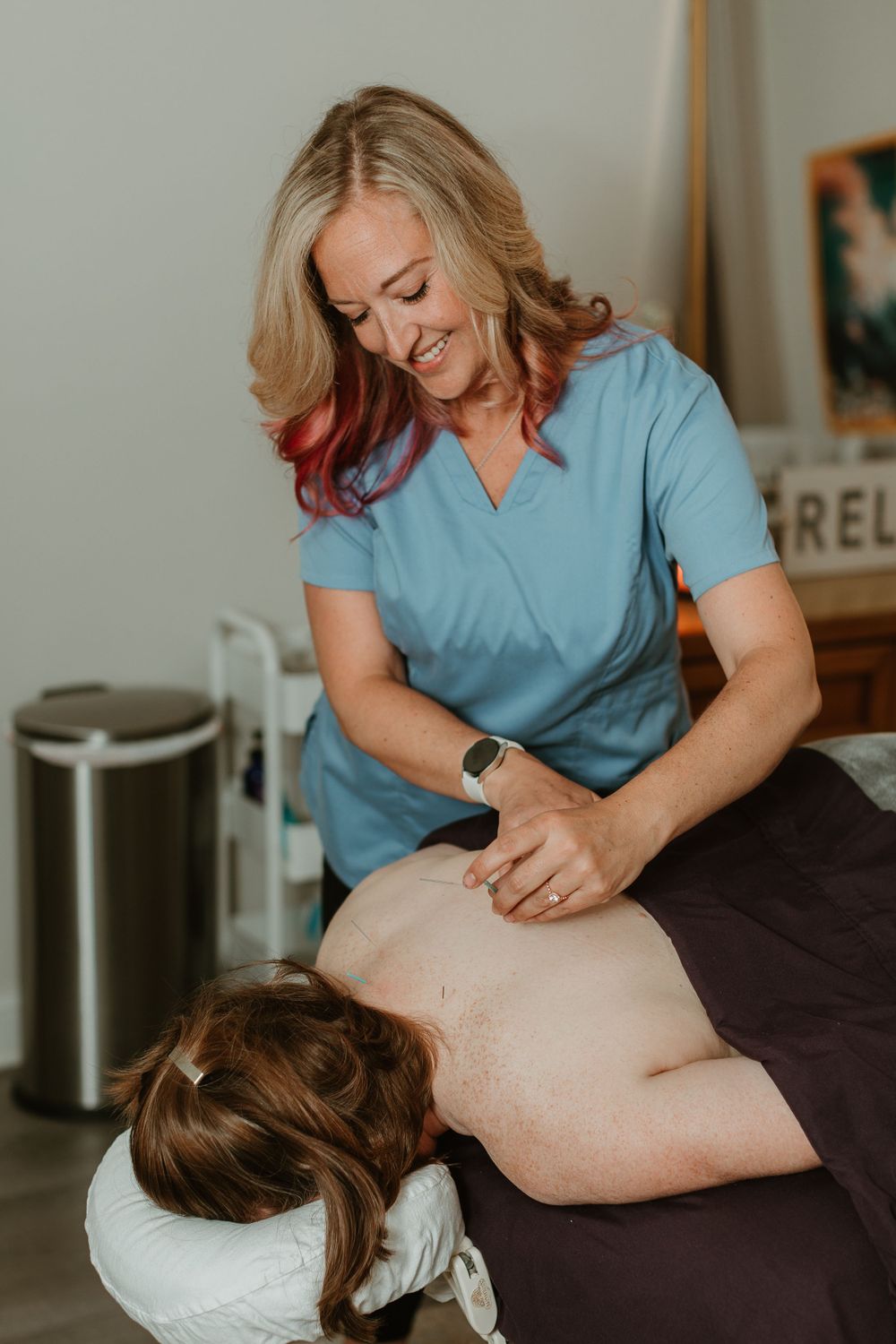 Healthcare provider performing therapeutic massage treatment on massage table.