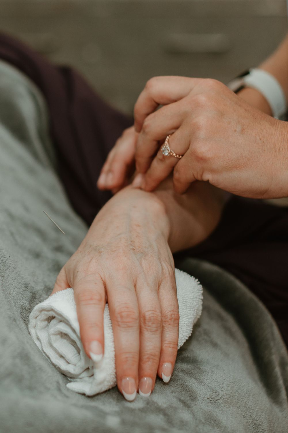 Close up of hands performing therapeutic treatment with white towel.