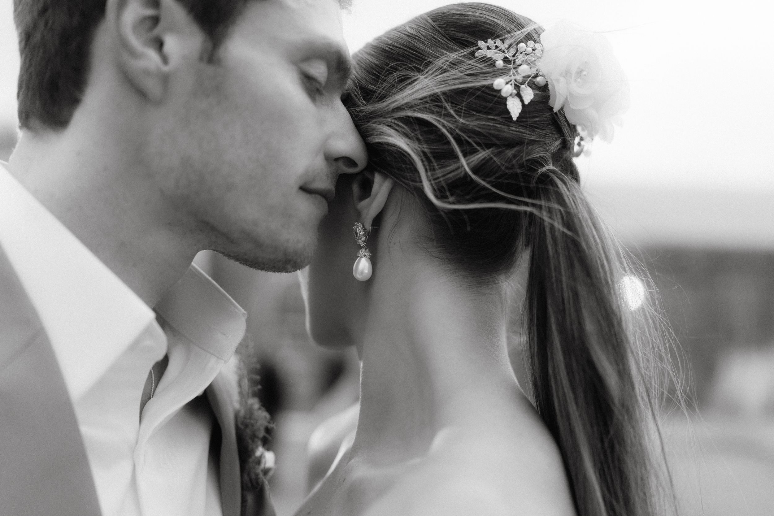 An intimate black and white portrait of a tender moment between newlyweds.
