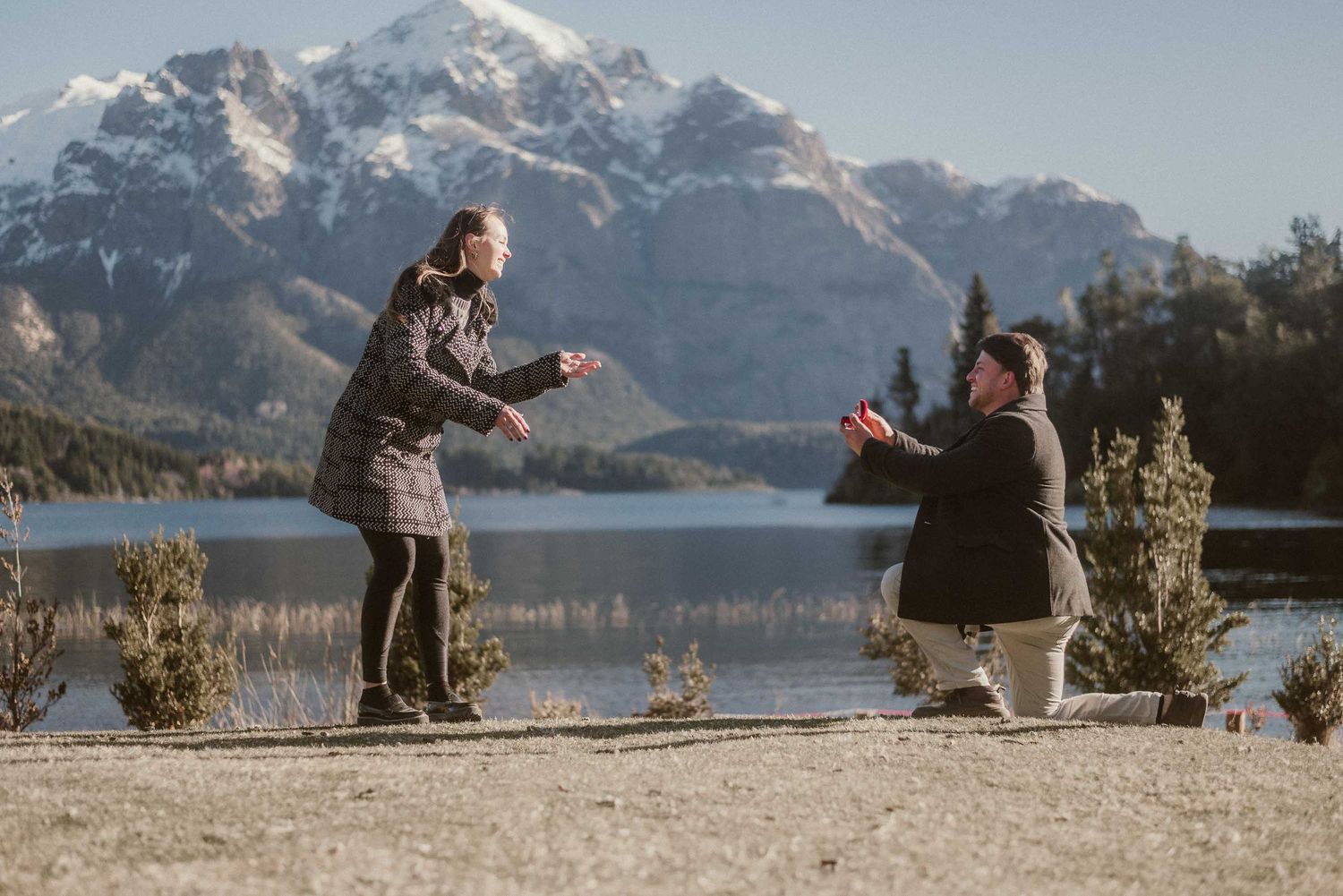 Pedido de mano romántico y sorpresa frente al Lago Nahuel Huapi con el emblemático Hotel Llao Llao de fondo en San Carlos de Bariloche.