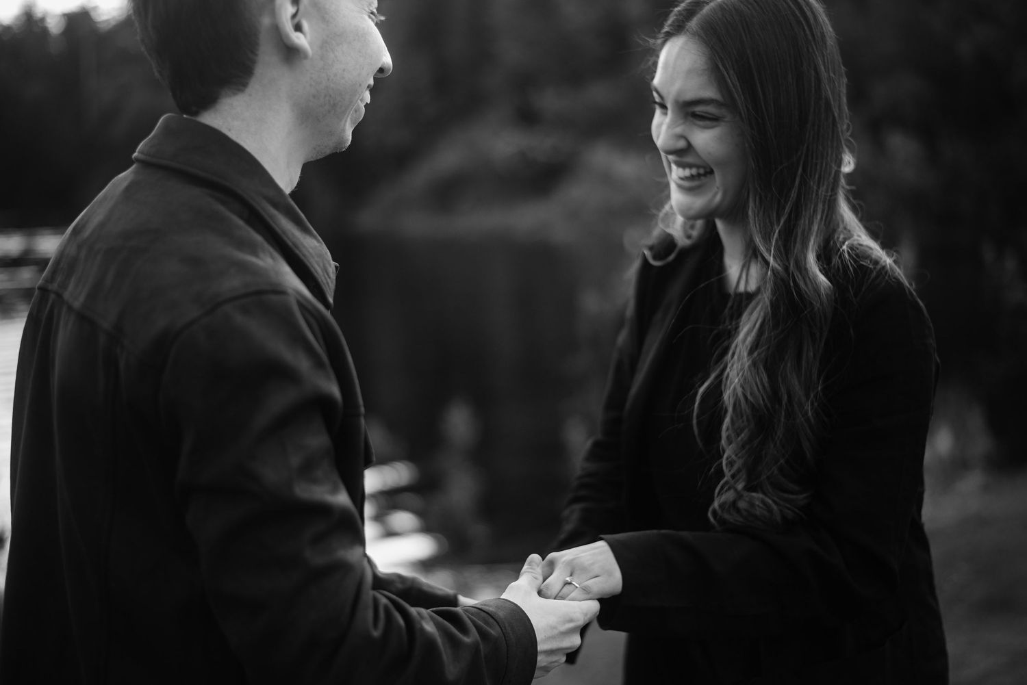 Retrato cercano y espontáneo de pareja durante una sesión de compromiso al aire libre en Bariloche hotel llao llao