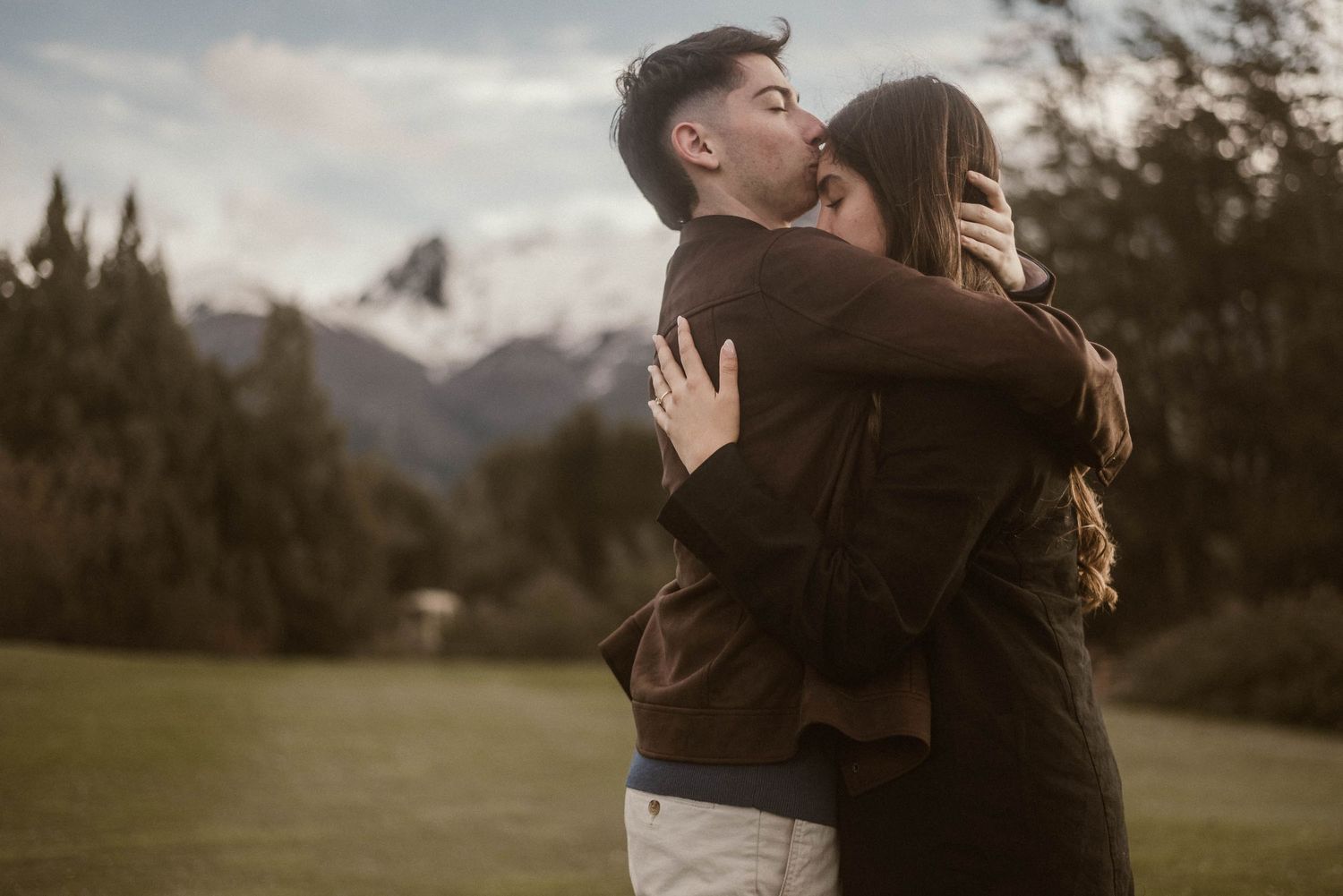 Atardecer romántico y abrazo de pareja en una propuesta de matrimonio organizada en la Patagonia en Bariloche Hotel Llao Llao