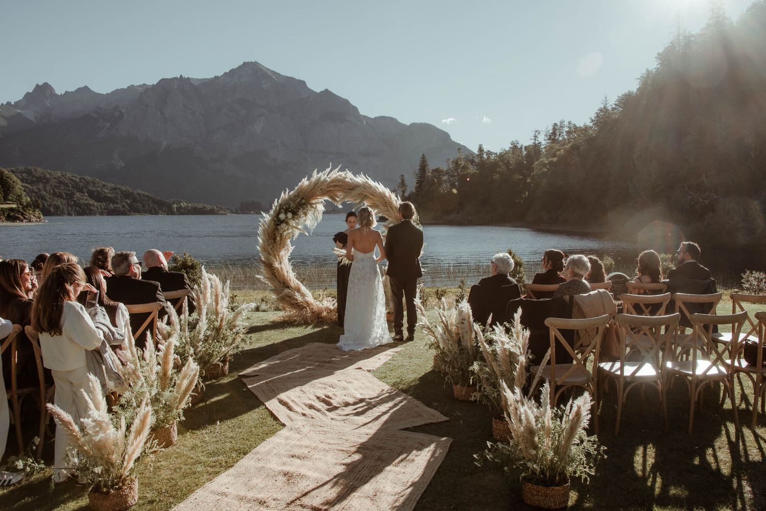 Casamento de luxo em cenário histórico. Noivos caminhando pelos jardins do hotel mais emblemático de Bariloche sob a luz dourada da tarde