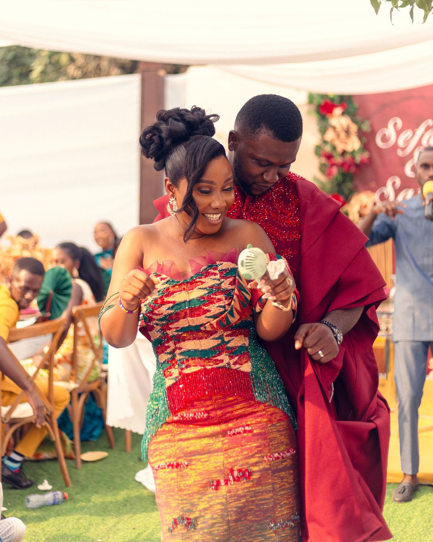 Celebration moment at outdoor event with decorative setup and traditional attire.