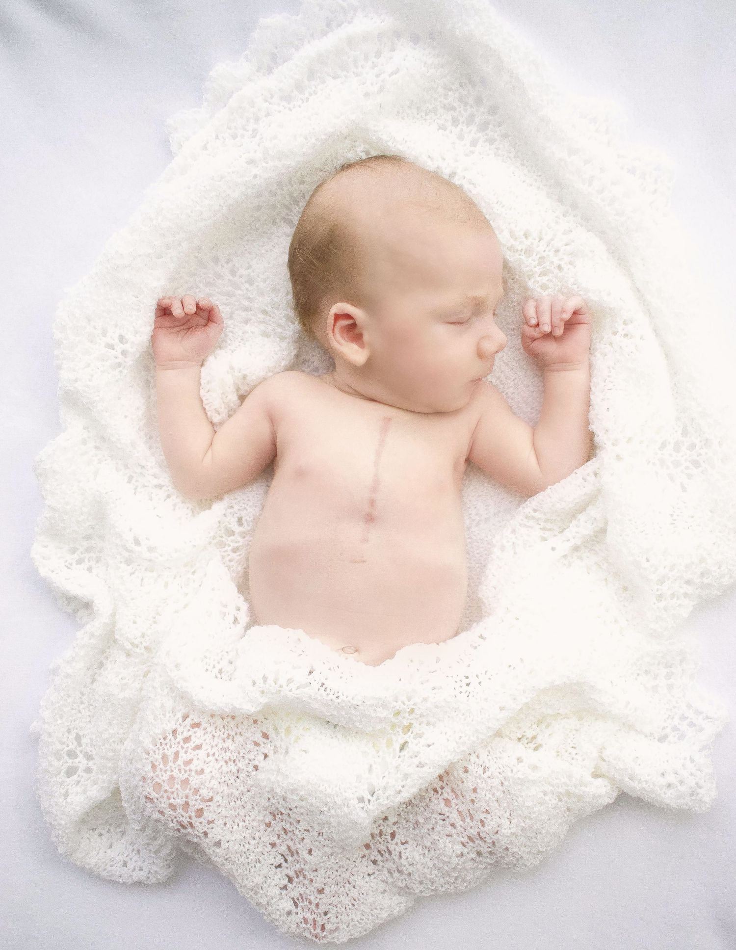 Newborn baby sleeping peacefully on delicate white lace blanket in various poses.