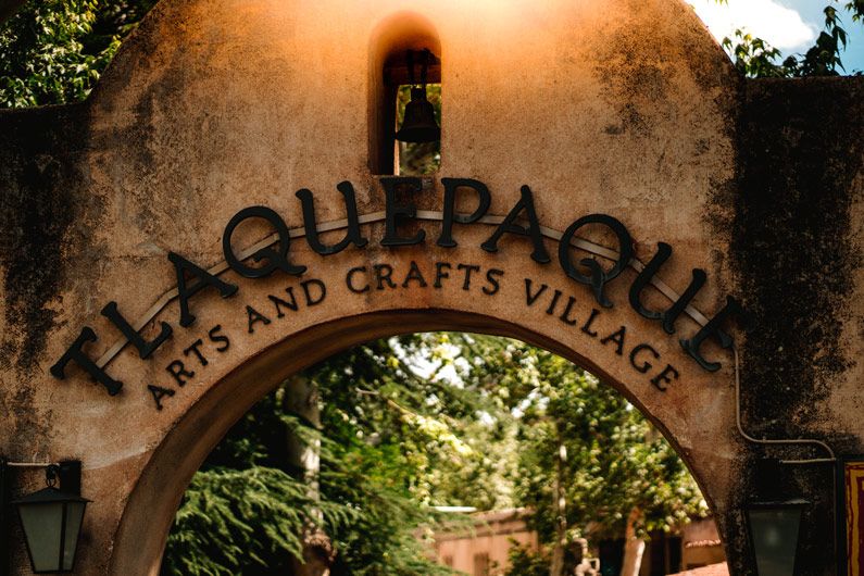 Entrance archway to Tlaquepaque Arts and Crafts Village, in Sedona with decorative signage.