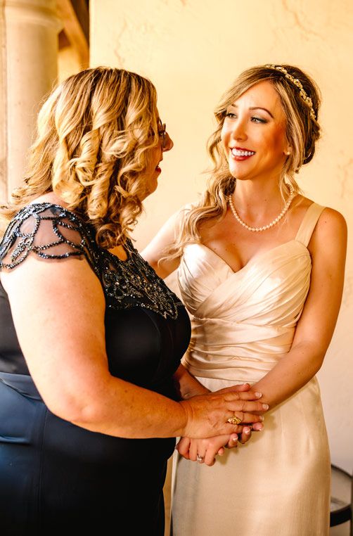 Two people share an intimate moment in formal attire with pearl accessories and elegant styling.
