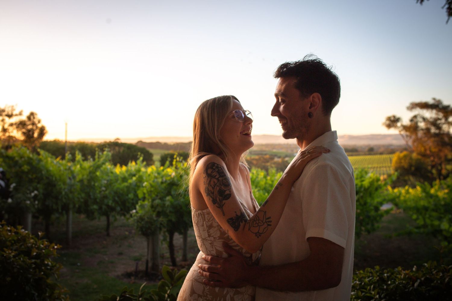 Romantic sunset moment between couple in vineyard setting.
