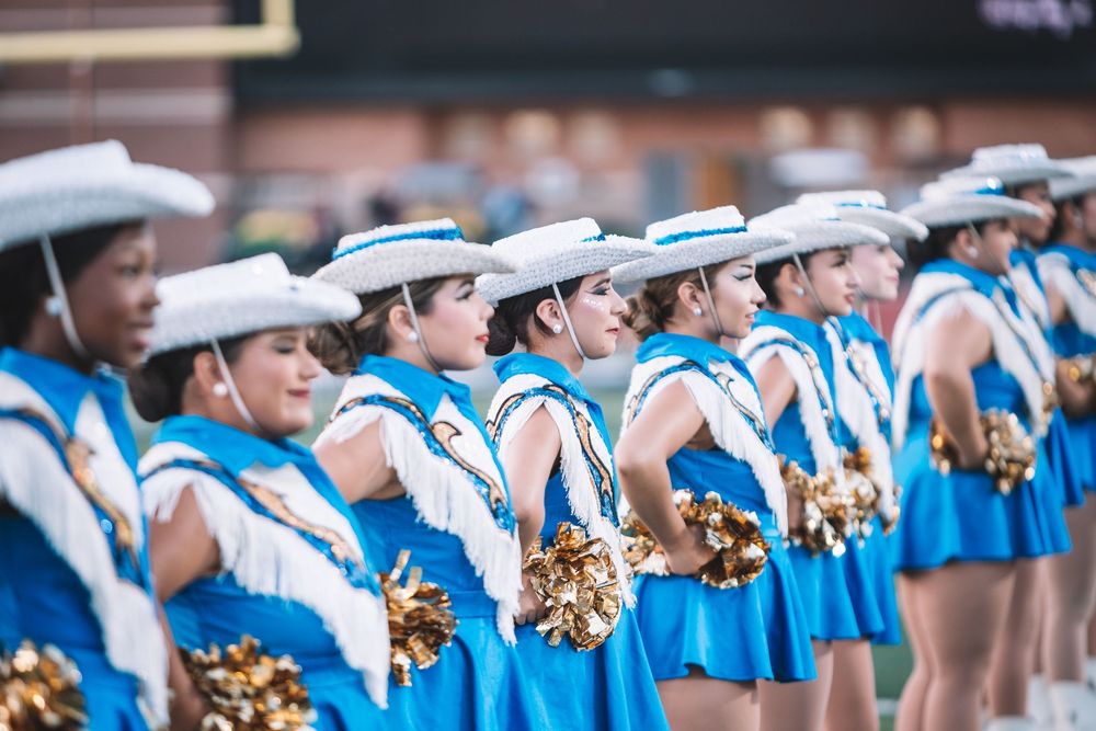 Drill team line in blue and white uniforms performs during halftime show.
