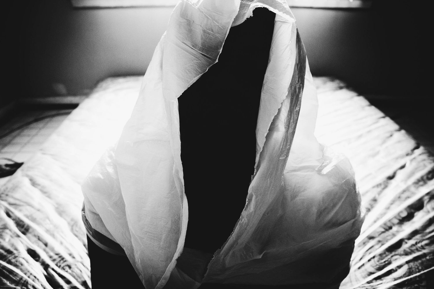 Black and white abstract photo series showing flowing fabric and dramatic light creating ethereal shapes and shadows.