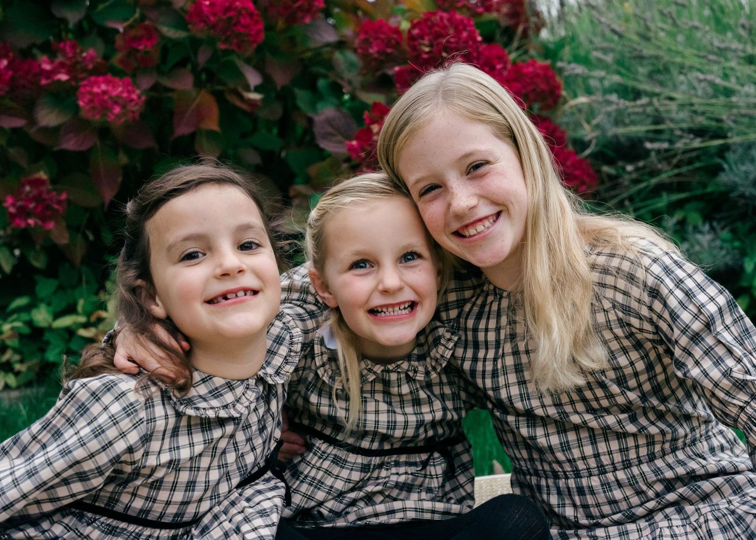 Lifestyle family photography of three sisters outdoors, photographed naturally during a documentary family session.