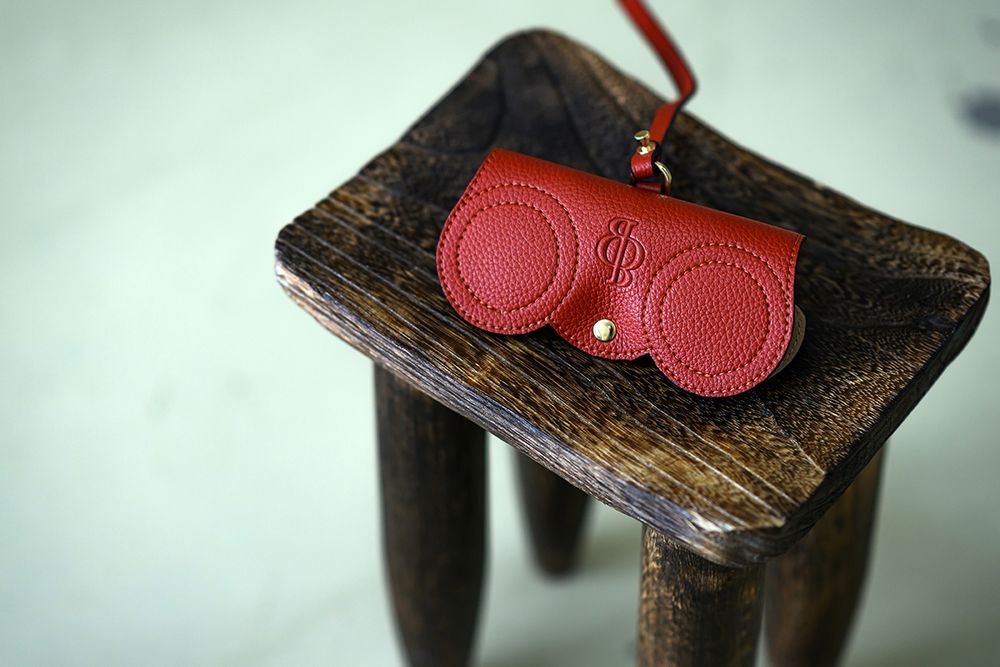 Red leather speaker discs mounted on rustic wooden surfaces shown from multiple angles in a product photography sequence.