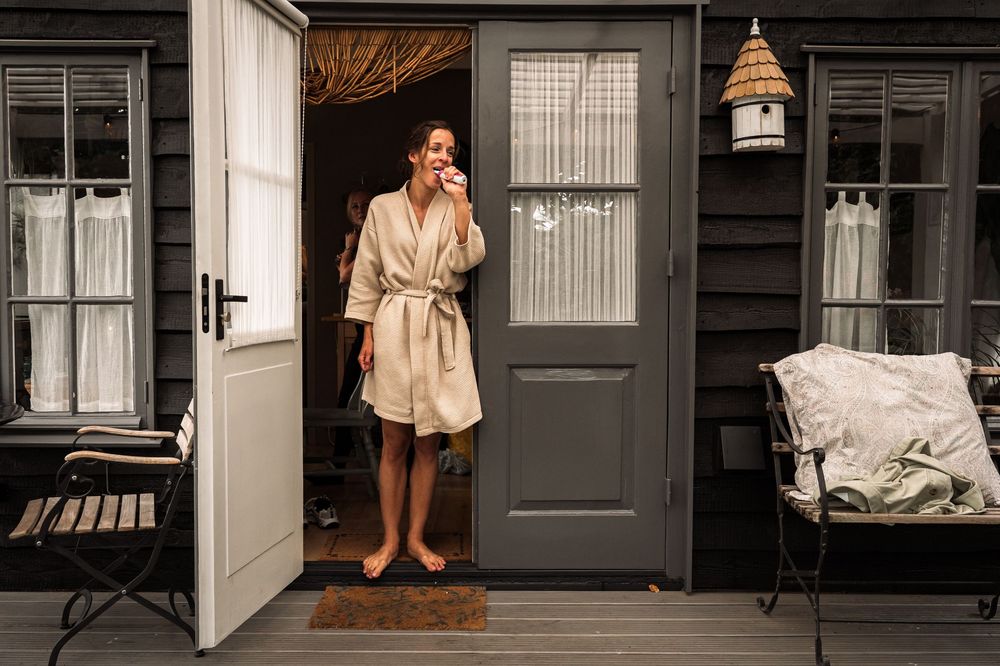 A cozy porch scene with a beige robe, grey door, and decorative birdhouse.