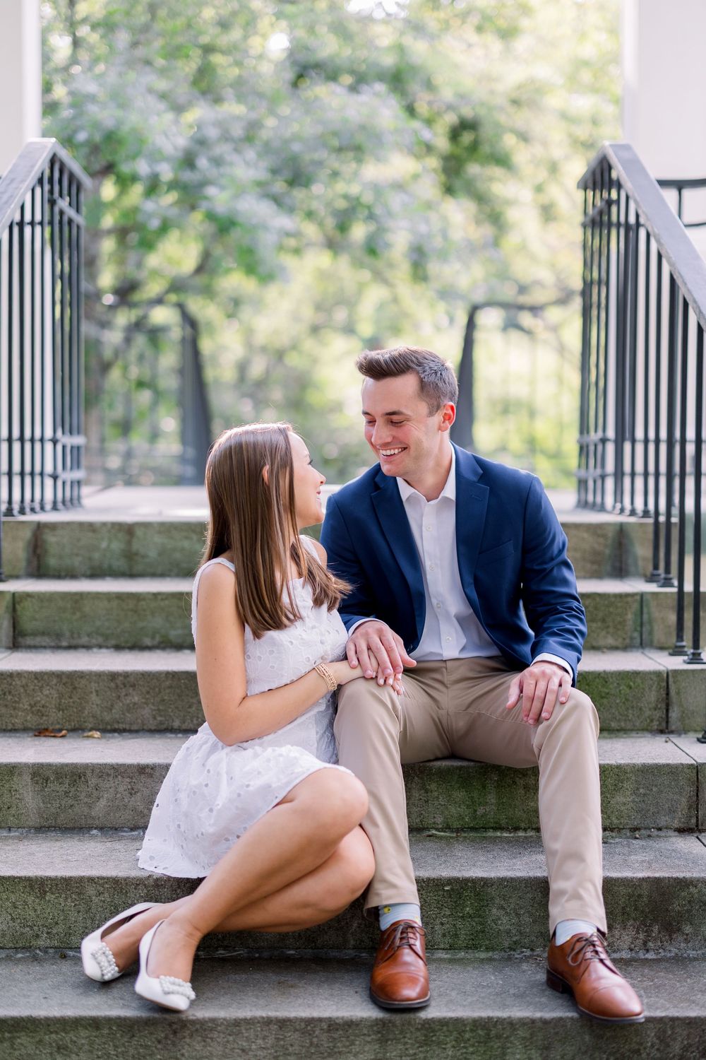 Couple sitting on stone steps during romantic outdoor photoshoot.
