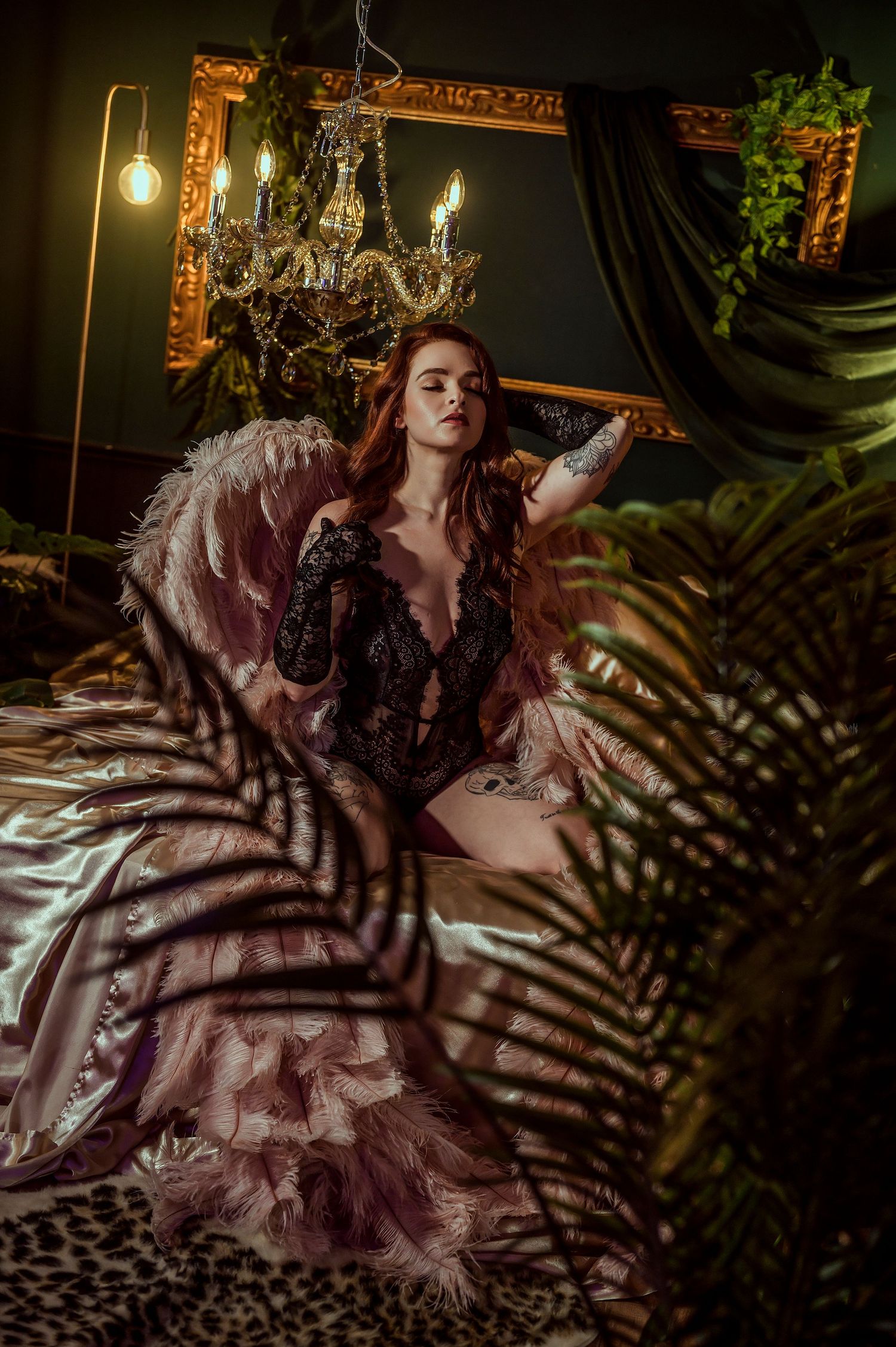 A dramatic boudoir photoshoot in moody lighting with palm frond shadows creating artistic patterns.