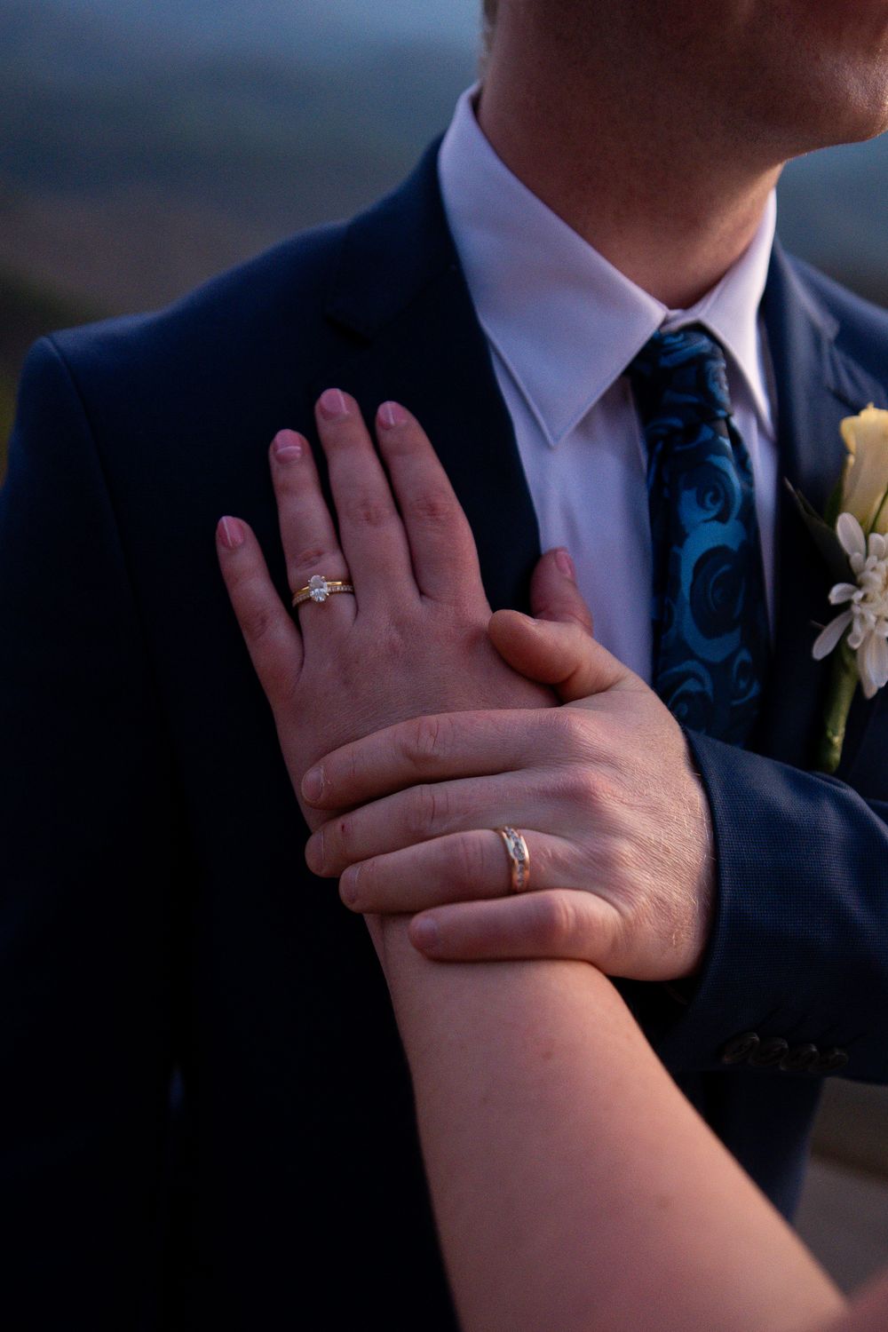 A sequence of close-up shots showing wedding rings on hands against a dark formal attire background.