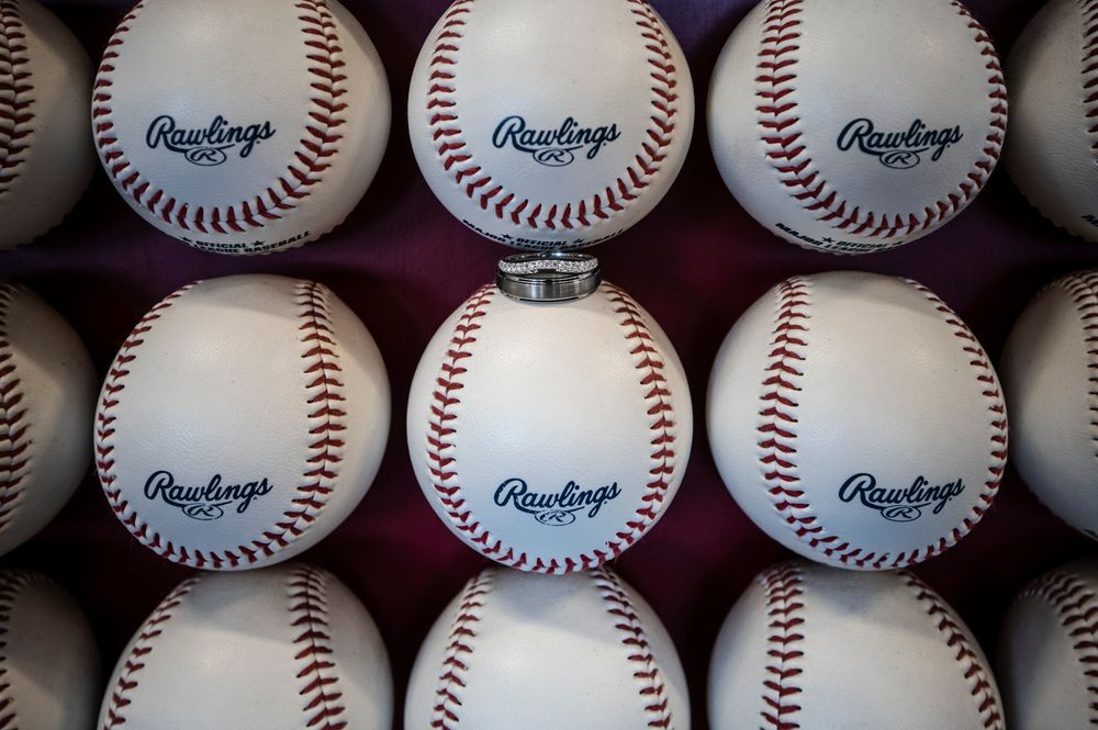Close-up view of multiple white leather baseballs with red stitching arranged in neat rows.