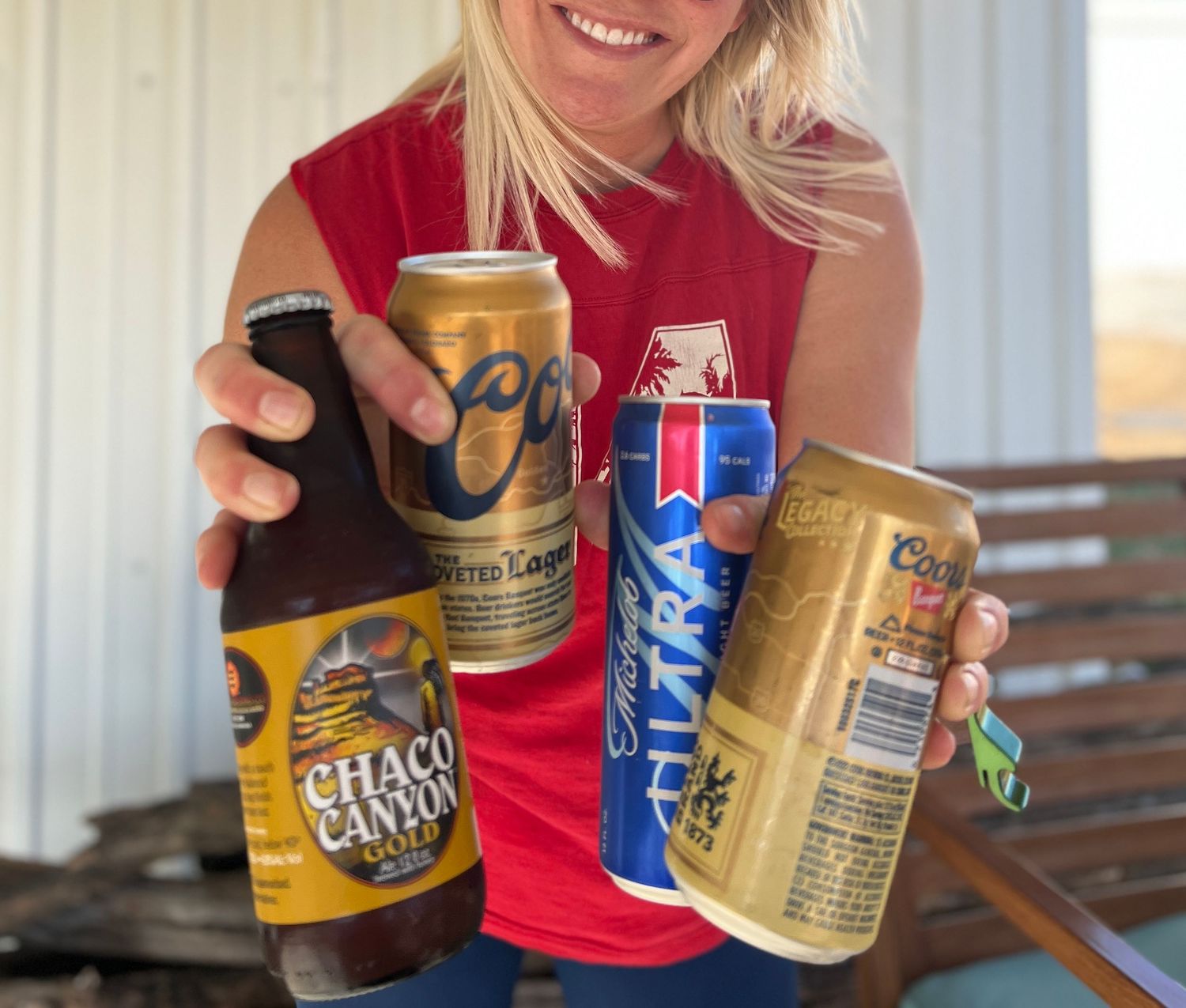 Friends holding various canned beverages while celebrating outdoors.