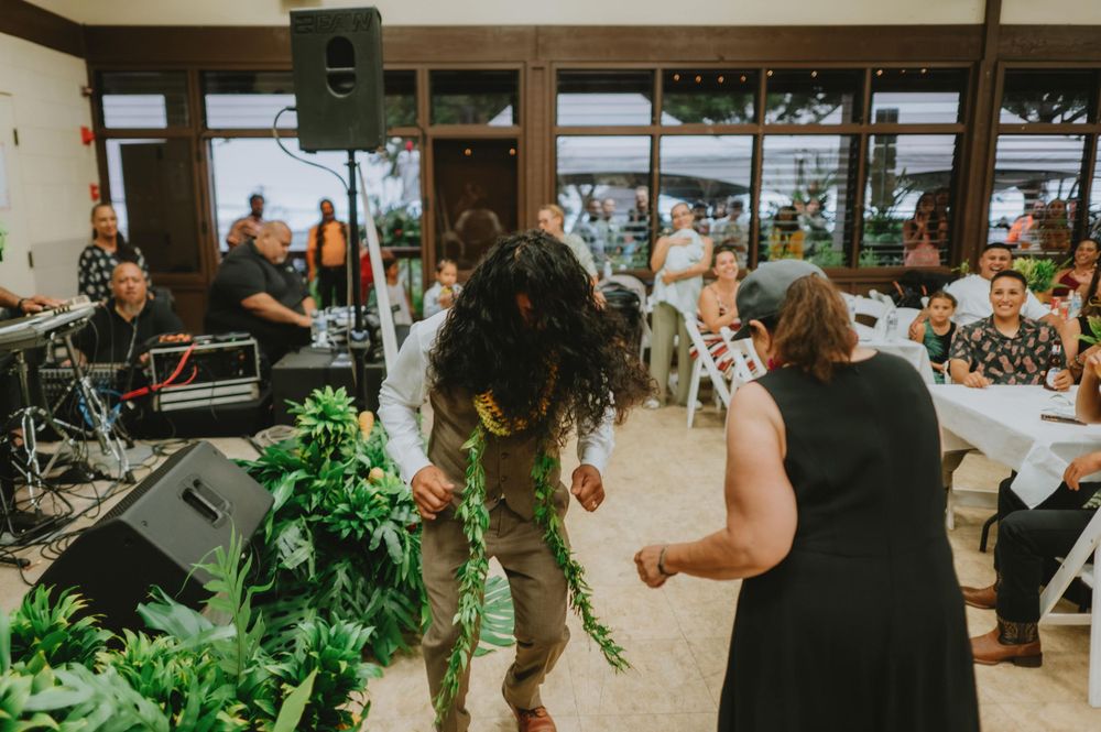 Wedding reception venue decorated with greenery and string lights.