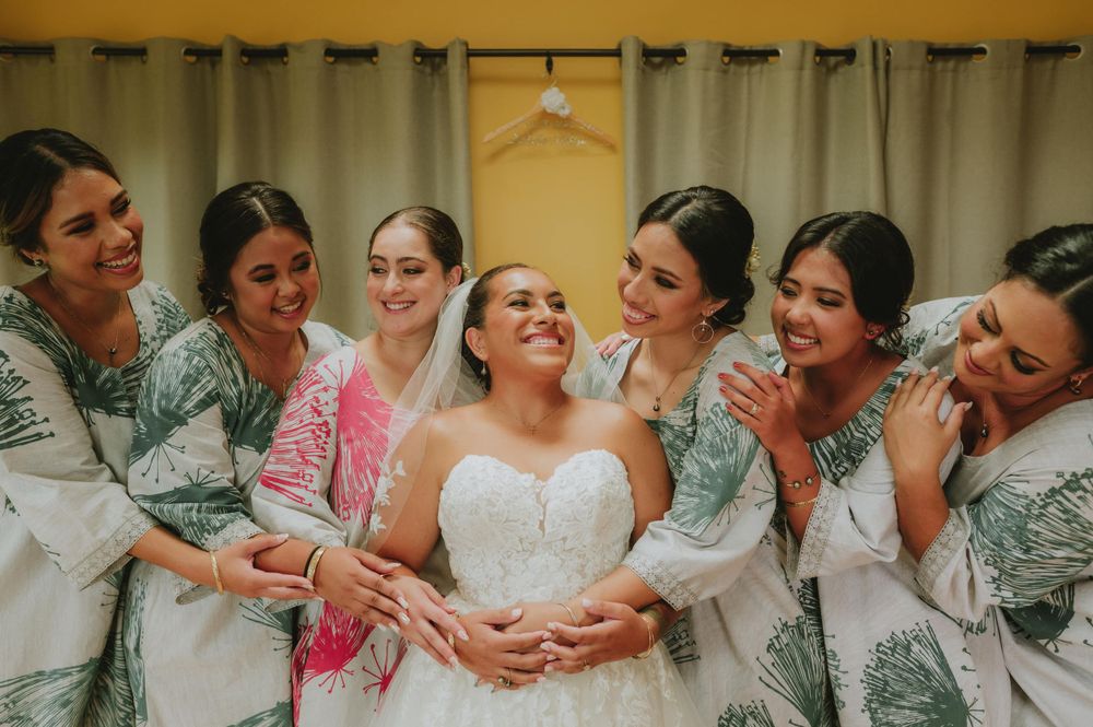 Wedding party in teal dresses poses together for candid group photos.
