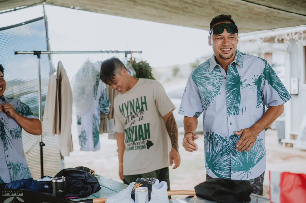 Groomsmen in tropical print shirts and casual attire gather outdoors.