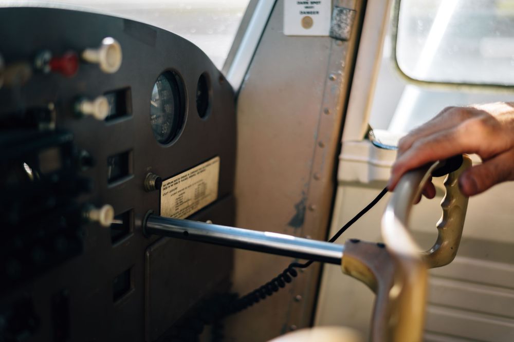 Close-up of a hand adjusting controls on an aircraft instrument panel.